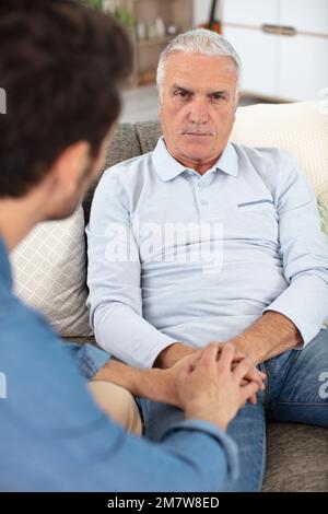 caring son talking to elderly father Stock Photo