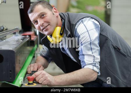 portrait of mature factory worker smiling at camera Stock Photo