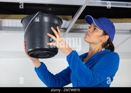 female electrician installing ventilation in ceiling Stock Photo
