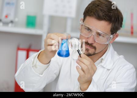 scientist using a magnifying glass in a test tube Stock Photo