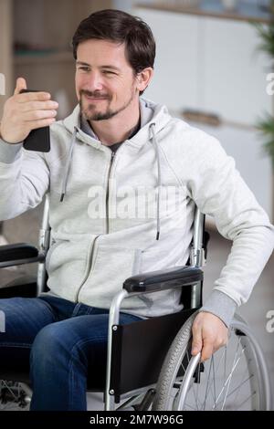 young man wearing casual clothes looking at smartphones screen Stock Photo