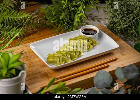 Steamed green spinach dumplings served with soy sauce Stock Photo