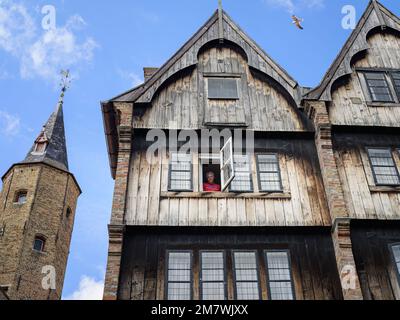 Bruges, Belgium - July 4, 2022: Traditional house in Bruges with an old man, daylight, summer Stock Photo