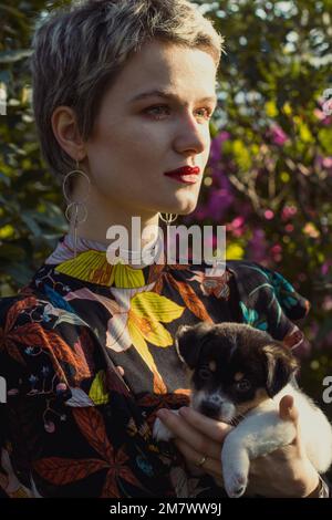 Close up short haired lady with puppy in orchard portrait picture
