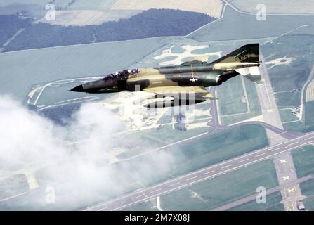 An air-to-air left side view of an RF-4C Phantom II aircraft in flight over the cliffs of Dover, England. The aircraft is from the 1ST Tactical Reconnaissance Squadron, 10th Tactical Reconnaissance Wing. Country: Unknown Stock Photo