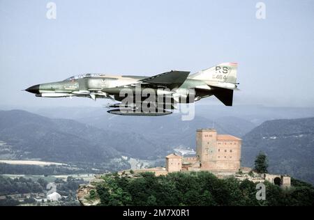 A low angle left side view of an F-4E Phantom II aircraft in flight. The aircraft, from the 526th Tactical Fighter Squadron, 86th Tactical Fighter Wing, is carrying four AIM-7 Sparrow missiles and four AIM-9 Sidewinder missiles. Country: Deutschland / Germany (DEU) Stock Photo