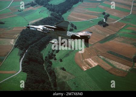 An air-to-air underside view of an F-4E Phantom II aircraft banking to the right. Base: Spangdahlem Air Base State: Rheinland-Pfalz Country: Deutschland / Germany (DEU) Stock Photo