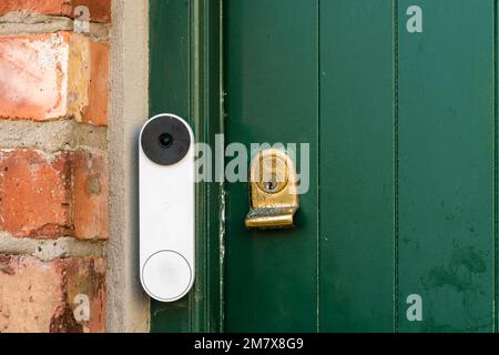 A video doorbell on a green door with a brass lock, United Kingdom, UK Stock Photo