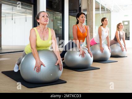 Women of various ages in upward-facing dog Stock Photo