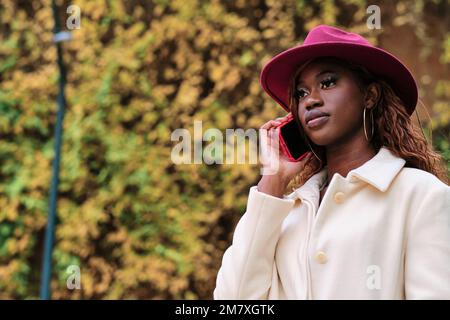 Stylish woman talking on the phone outdoors. Stock Photo