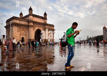 An Indian tourist eats an ear opposite the India Gate Stock Photo
