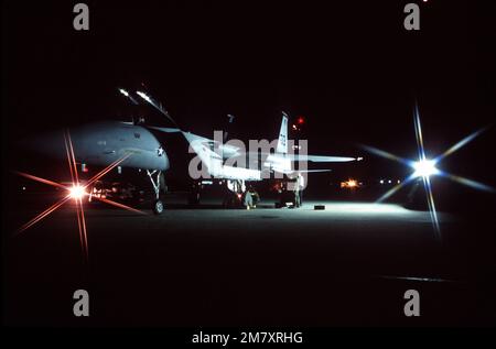 A right side nighttime view of a parked F-15 Eagle aircraft undergoing maintenance during the William Tell '82 competition. A star filter was used on the camera to obtain the special lighting effect. Subject Operation/Series: WILLIAM TELL '82' Base: Tyndall Air Force Base State: Florida (FL) Country: United States Of America (USA) Stock Photo