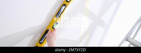 Builder uses building level to check verticality of wall Stock Photo