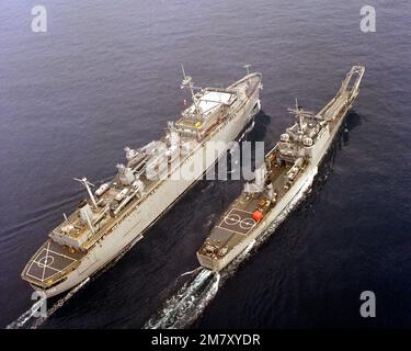 An elevated starboard quarter view of the destroyer tender USS ACADIA (AD-42) and the tank landing ship USS FRESNO (LST-1182) underway. Country: Pacific Ocean (POC) Stock Photo