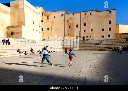 Fez, Morocco-April 25, 2014. Boys and children playing soccer in the square in one of the gates to enter to Medina of Fez in Marocco Stock Photo