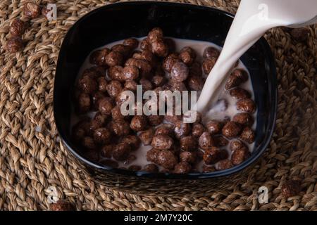 photo chocolate covered cereal balls with milk Stock Photo