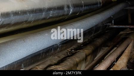 Plumbing communications on blurred background of darkness in house basement with local lighting Stock Photo