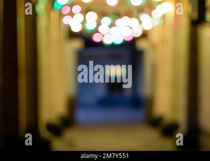 Defocused image of arcade with multi-colored light bulbs in the evening Stock Photo