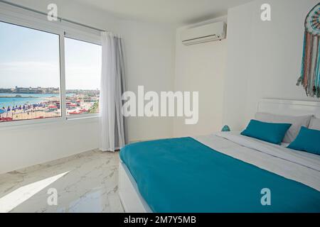Interior design decor furnishing of luxury show home bedroom showing furniture and double bed in resort with sea view from window Stock Photo