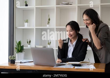 Group of Young Asian business team creative businesspeople coworker in office Happy to be successful partnership teamwork celebrating achievement and Stock Photo