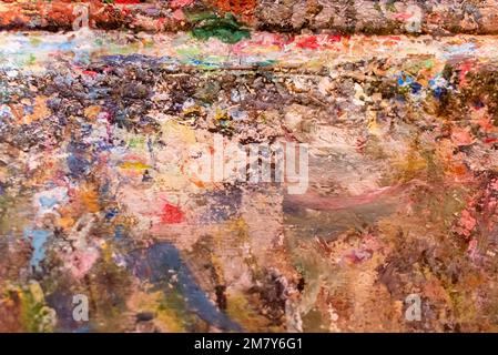 Multicolored abstract. Fragment of artist easel with dried paints on surface Stock Photo
