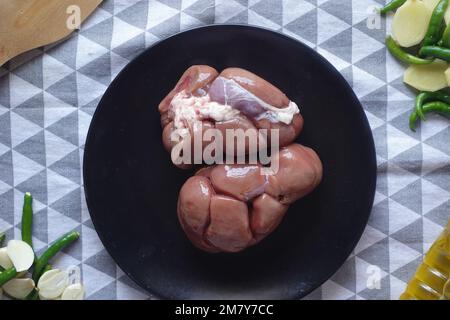 Raw fresh lamb kidneys on a chopping board  Stock Photo