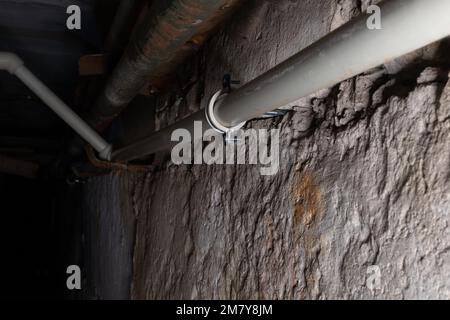 Plumbing communications on blurred background of darkness in house basement with local lighting Stock Photo