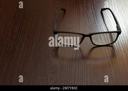 Stylish eyeglasses on office table close-up on blurred background Stock Photo
