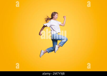 Full body young smiling happy woman hurry up isolated on yellow color background studio portrait. People lifestyle concept Stock Photo