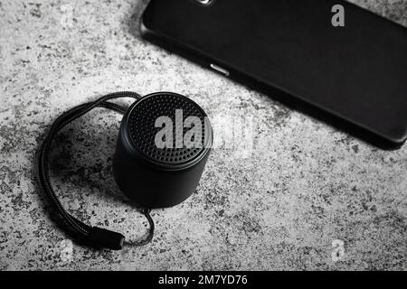 Black mini Bluetooth speaker and smartphone conected Stock Photo