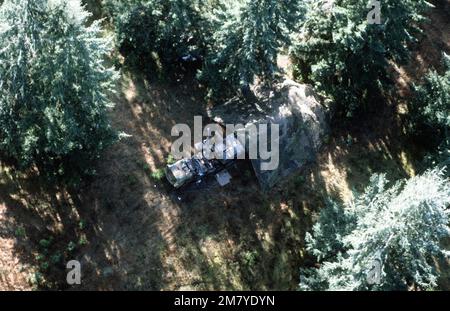 Aerial view of a transporter-erector-launcher (TEL) vehicle covered with camouflage netting, during ground launch cruise missile (GLCM) evaluation. Base: Fort Lewis State: Washington (WA) Country: United States Of America (USA) Stock Photo