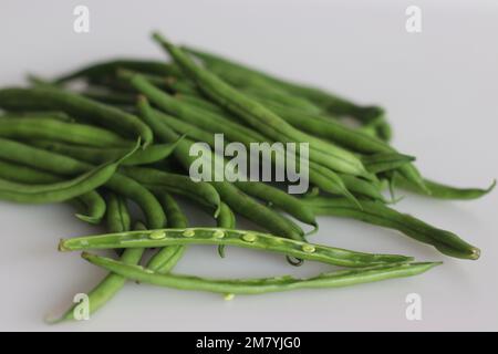 Bunch of French Beans shot on white back ground with few sliced half. It is also called green beans, bush beans, string beans, snap beans, haricot ver Stock Photo