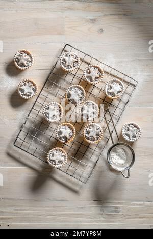 Flat lay mince pies topped with pastry stars, dusted with icing sugar ...