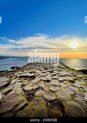 A view of a sunset from the Giant's causeway with structured bricks on the sea. Stock Photo