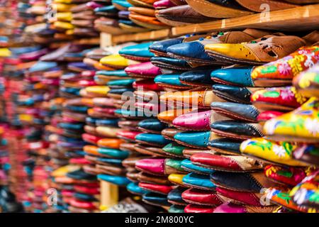 Colorful handmade leather slippers waiting for clients at shop in Fes, next to tanneries, Morocco, North Africa Stock Photo