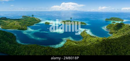 Extensive coral reefs fringe rainforest-covered islands in the Solomon Islands. This beautiful country is home to spectacular marine biodiversity. Stock Photo