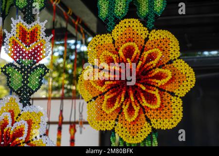 Mexican Huichol Beaded Chaquira Flower Necklaces in the market handmade crafts very laborious Stock Photo