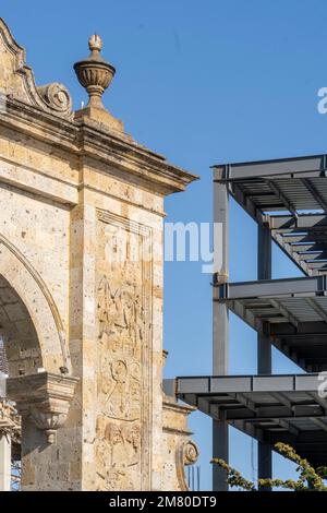 quarry stone arch in contrast to a building under construction in the steel background Stock Photo