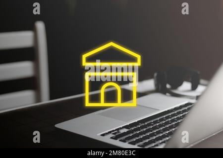 Yellow house icon on minimal workplace background. Smart house concept Stock Photo