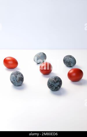 Defocus blue and red eggs on white background. Minimal Easter celebration concept. Design, visual art, minimalism. Balance and harmony concept. Mental Stock Photo