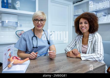 Expericenced gynecologist showing the anatomical model to junior colleague Stock Photo