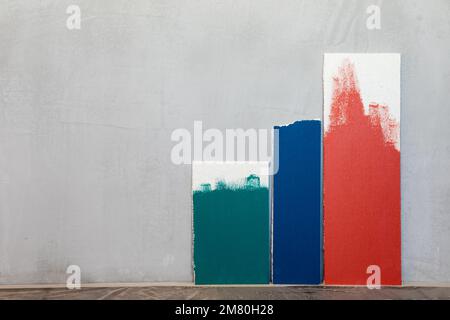 Green blue and red color samplers at blank gypsum plaster wall. Choosing wall paint color during house renovation Stock Photo