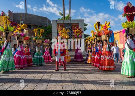 Chinas Oaxaquenas dancers with decorated flower baskets on their heads at the Guelaguetza festival in Oaxaca, Mexico.  A male singer also performs. Stock Photo