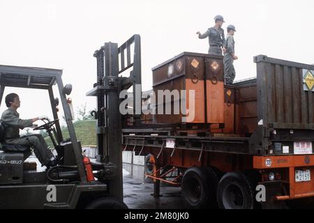 Korean troops use a forklift to remove crates of 30mm munitions from an ...