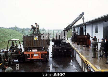 Korean troops use a truck crane to unload an open flatrack container ...
