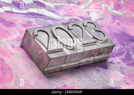 2023 year in grunge metal type against colorful marbled paper, New Year concept Stock Photo