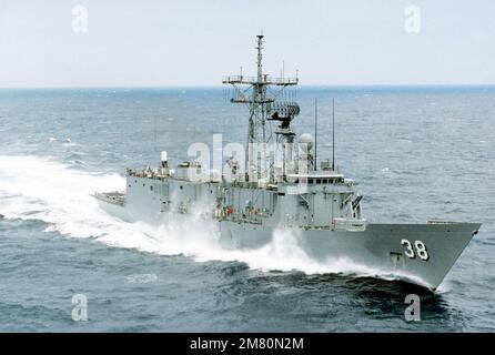 An aerial starboard bow view of the guided missile frigate USS CURTS (FFG 38) underway. Country: Unknown Stock Photo