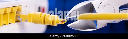A cutter for cutting a network cable cuts a cable close-up. Stock Photo