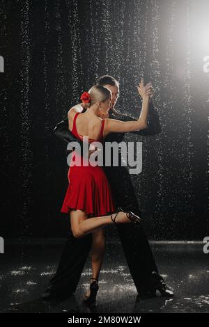 A couple of dancers on a black background in a studio in the aqua zone Stock Photo