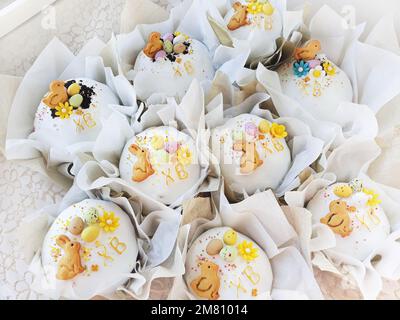 Easter pastries are decorated with figurines of rabbits, chickens and eggs in sunlight Stock Photo